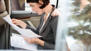 Una dona llegint documents per reclamar un recàrrec de prestacions